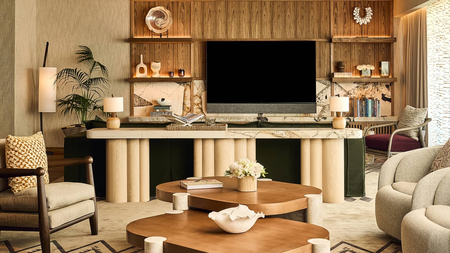 Stylish resort suite living room with arm chairs and two matching wood and stone coffee tables