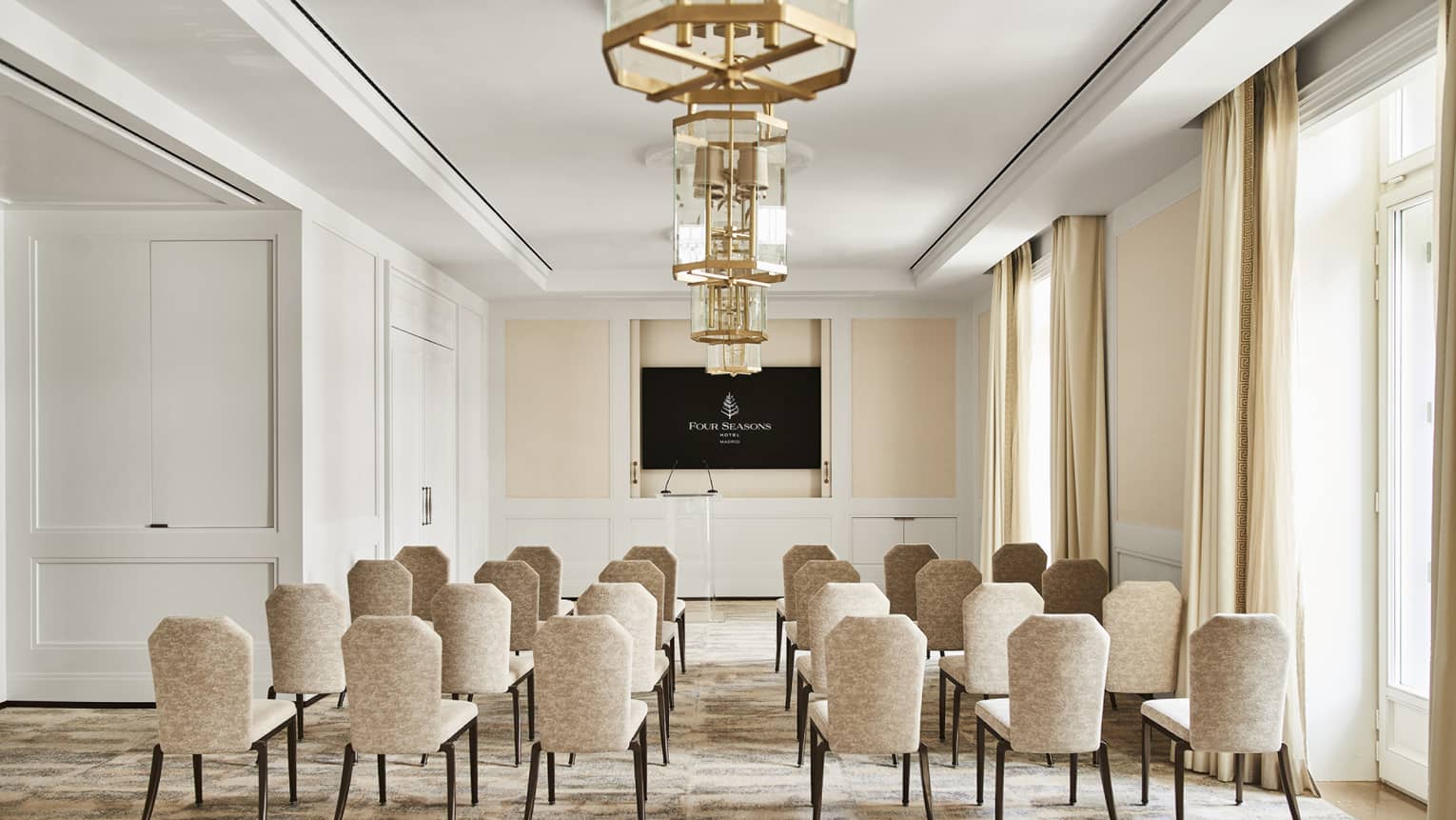 Classroom-style meeting room setup with TV screen at the front of the room.