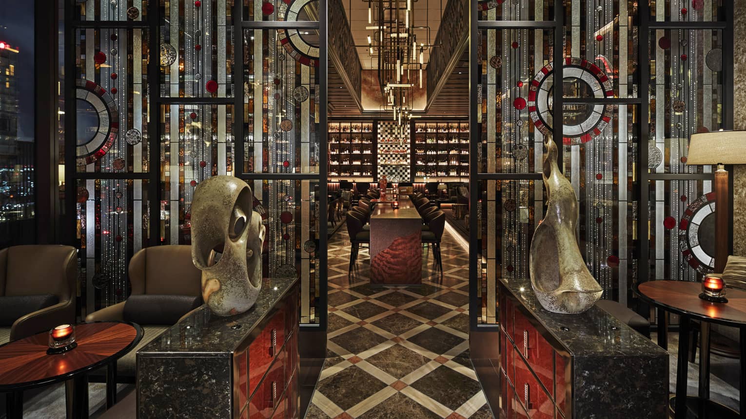 Entryway to VIRTU with sculptures, low lighting, red and black accents