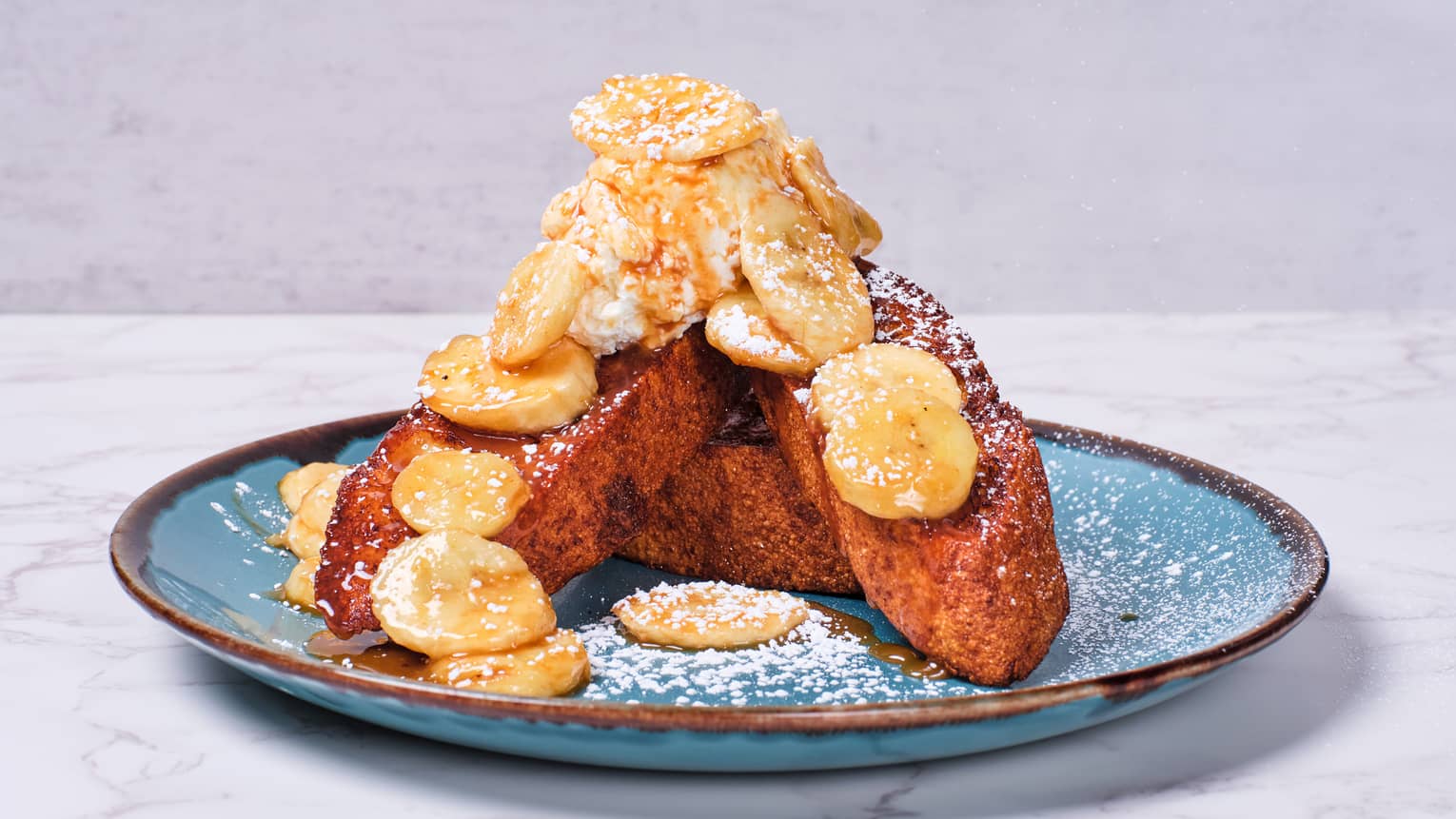 French toast topped with powdered sugar and banana slices