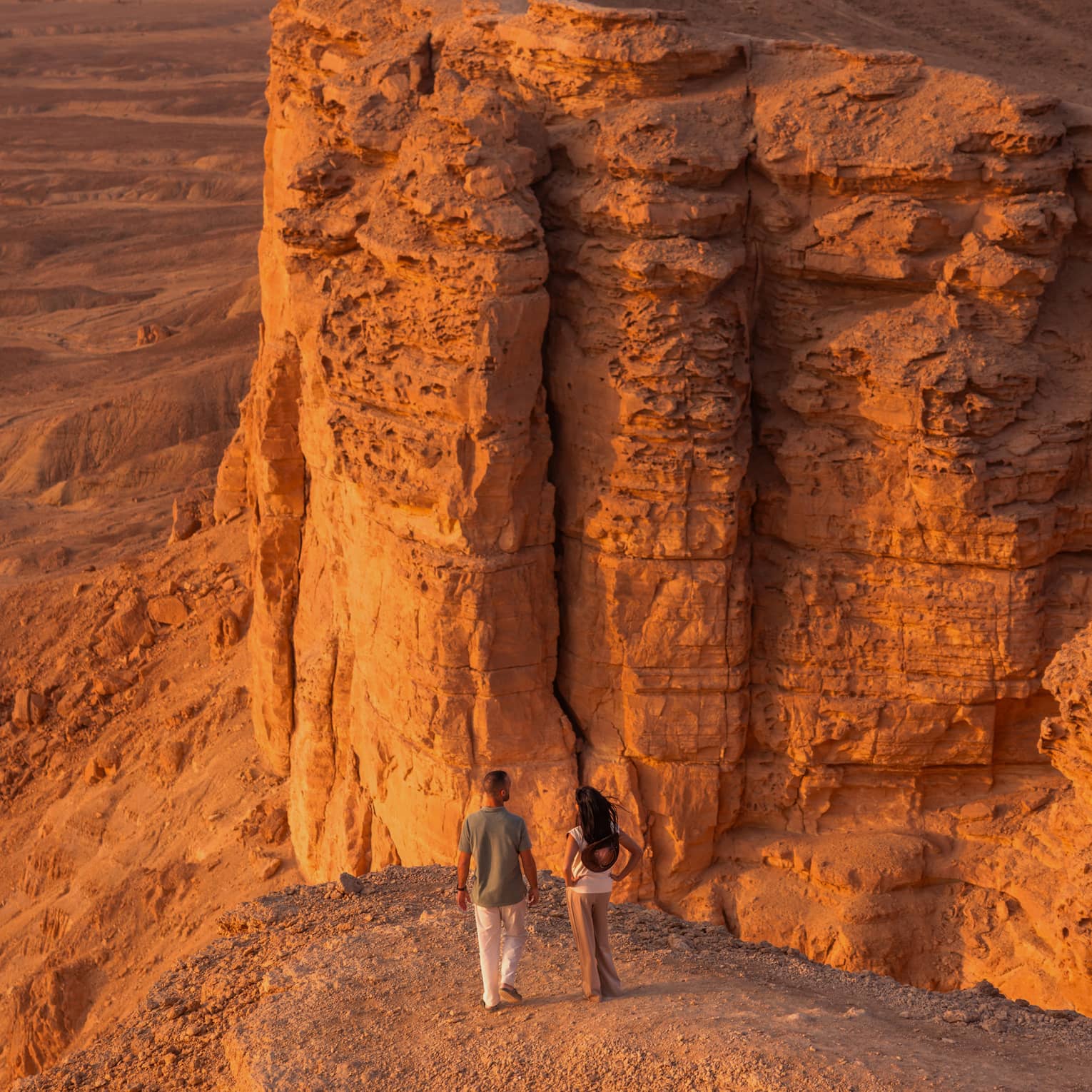 Two people walking in a desert landscape