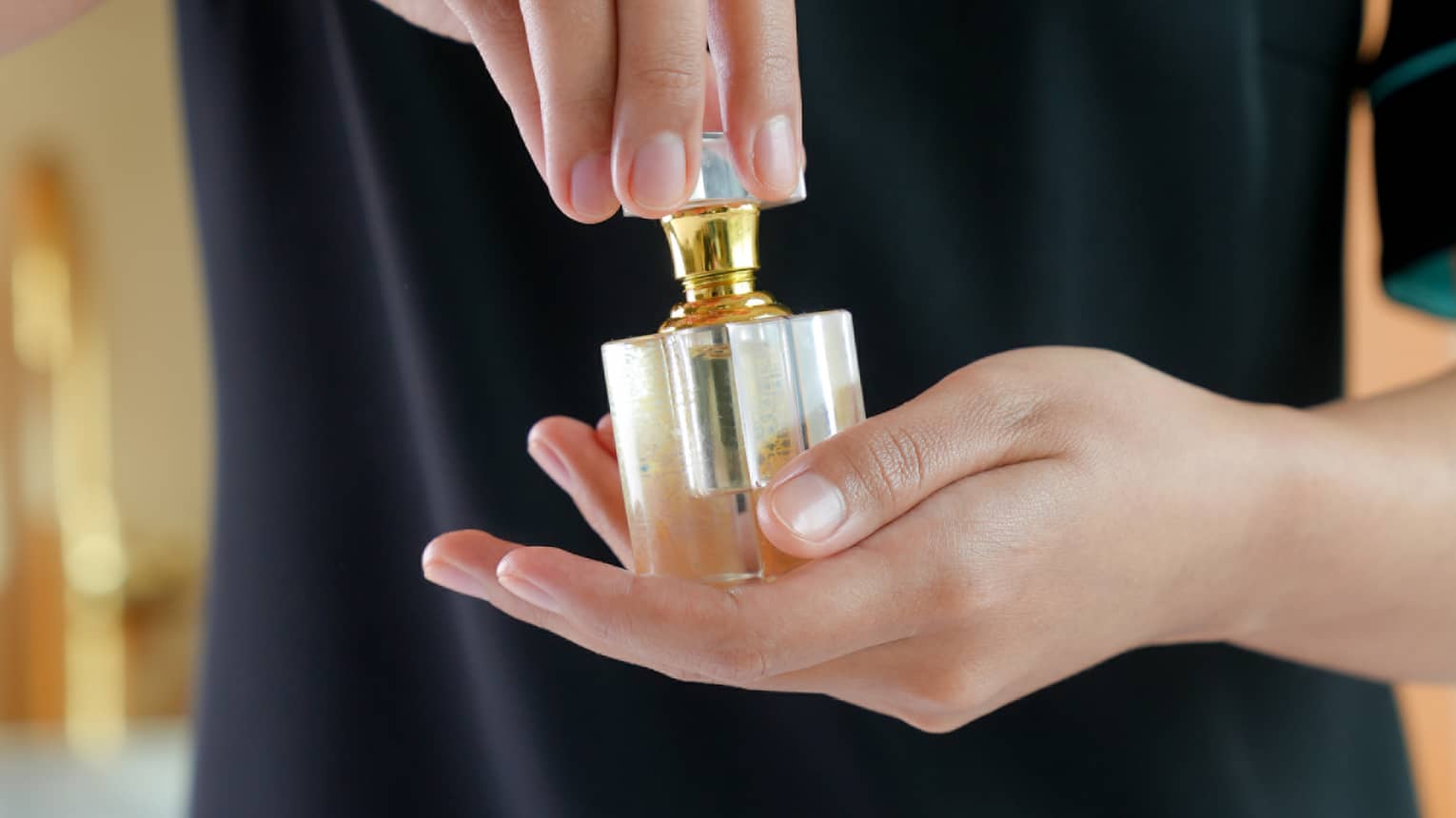 A spa attendant holding a square, glass fragrance bottle