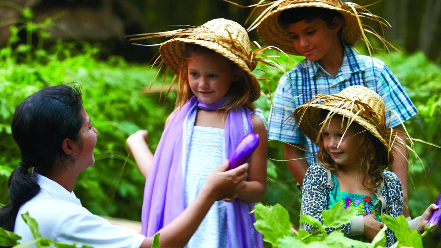 Three children learning about food and culture in a chef-guided class outdoors