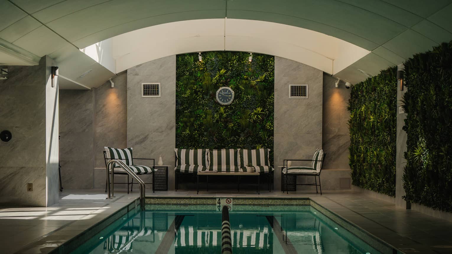 An indoor pool with a seating area and a vaulted ceiling