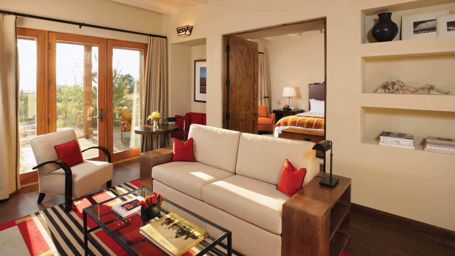 Summit Suite seating area with white loveseat, chair, open wood doors to bedroom