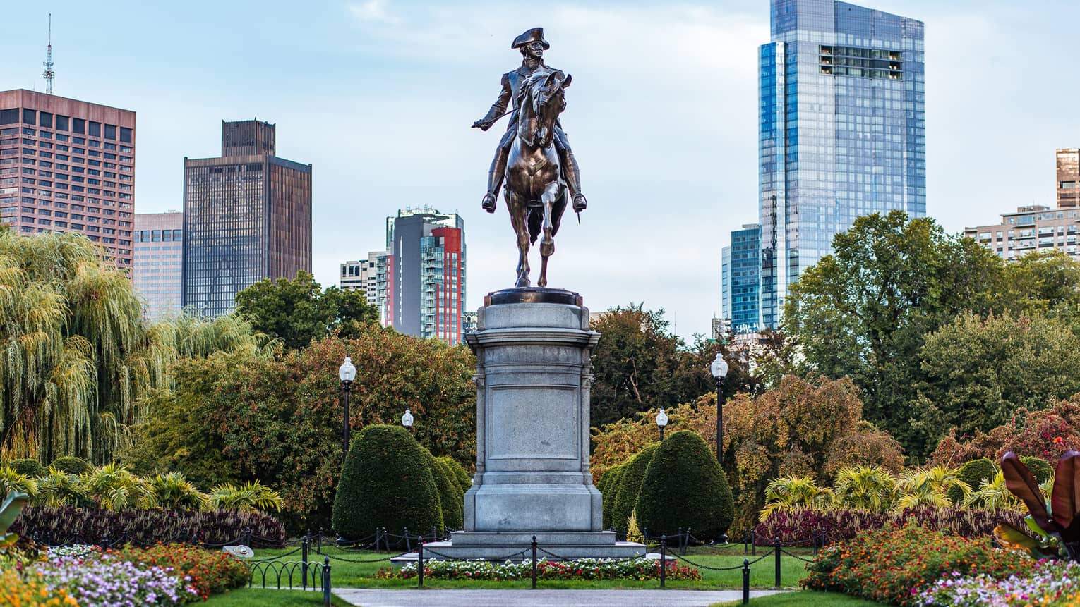A large statue of a man on horseback in the middle of a garden.