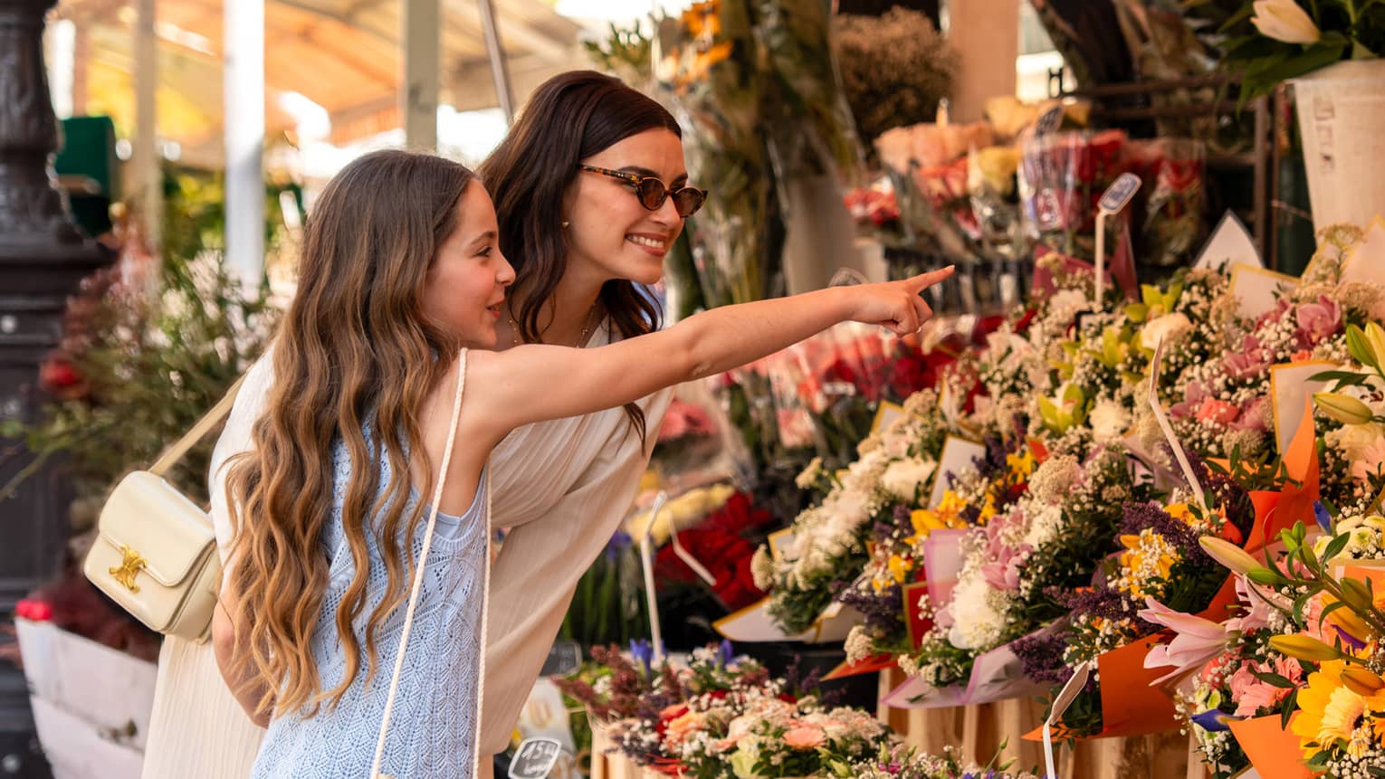 Two guests standing near a display of flowers at an outdoor shop