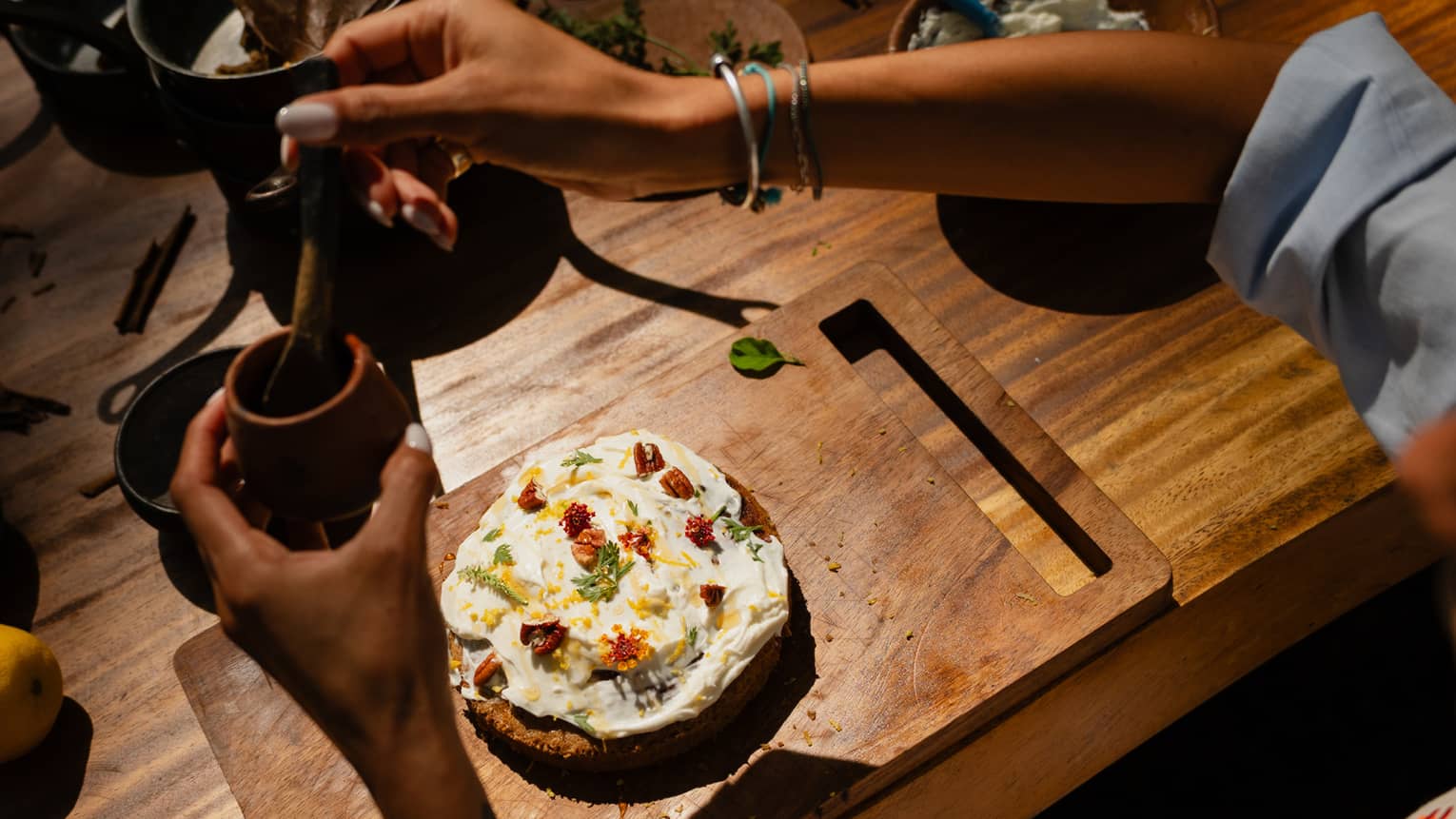 A person prepares food at a wood table.