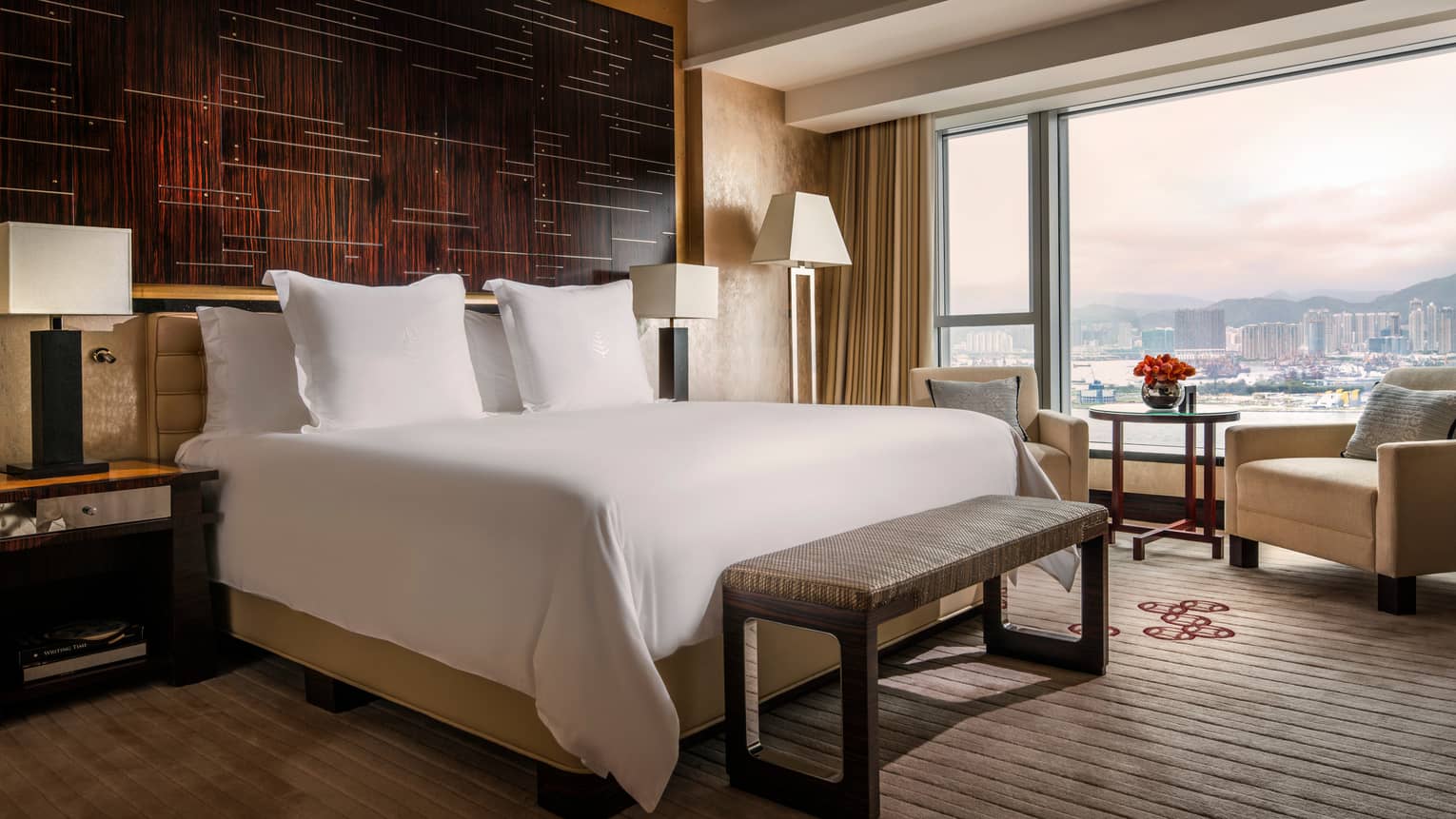 Club Premier Harbour-View Room bed and bench in front of dark wood panel wall, large window