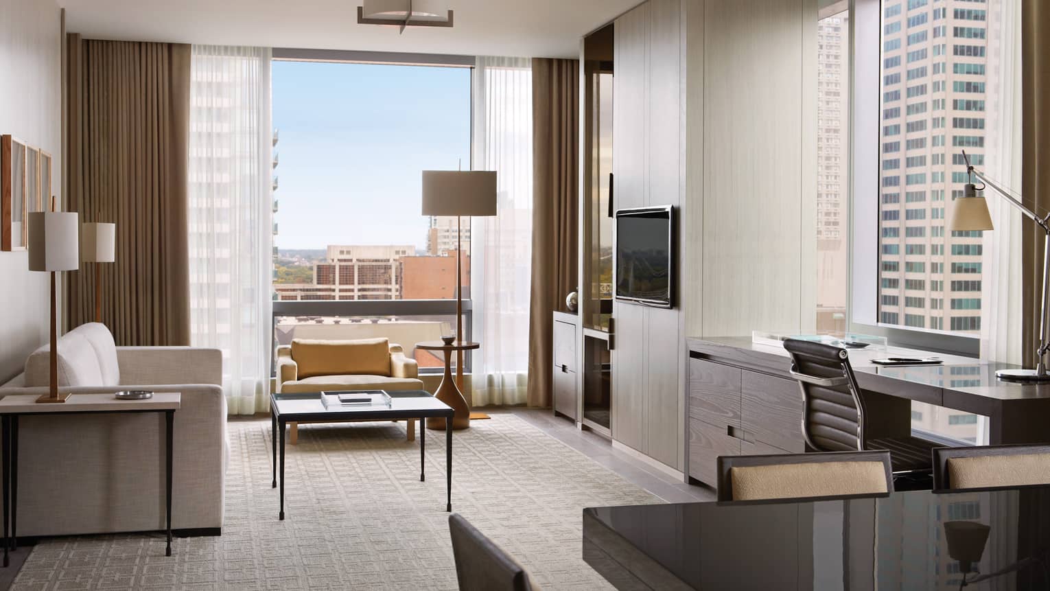 Yorkville Suite seating area, table under sunny corner window, TV, desk, dining table