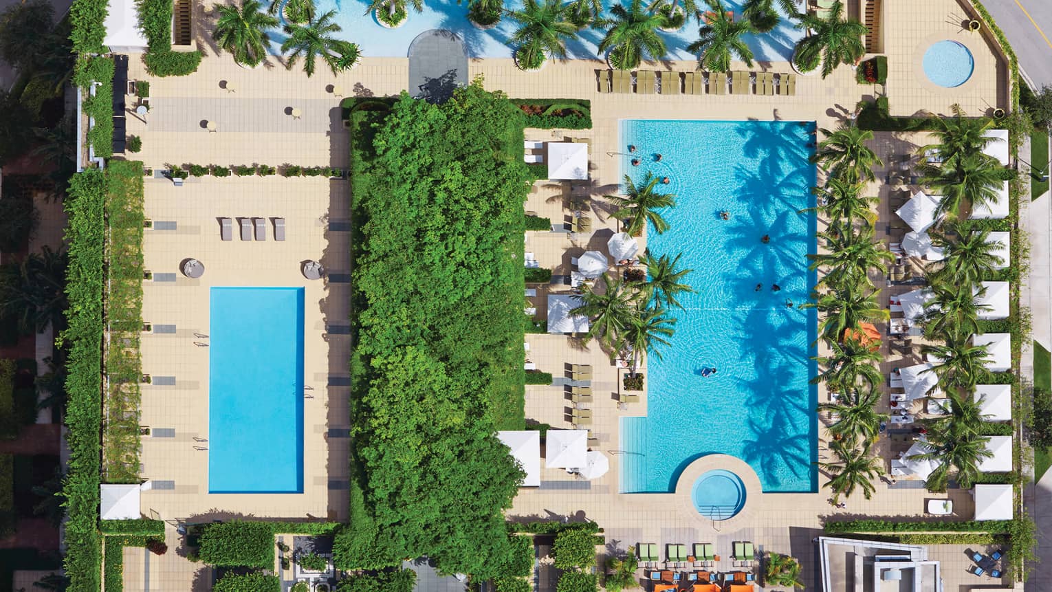 Aerial view of blue outdoor swimming pools, trees 