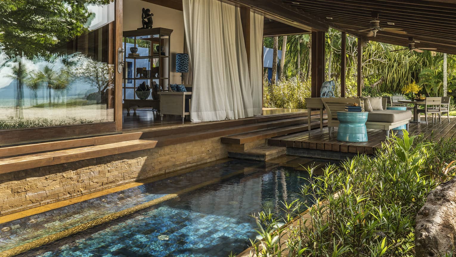 White curtains hang from Beach Villa patio over tile plunge pool