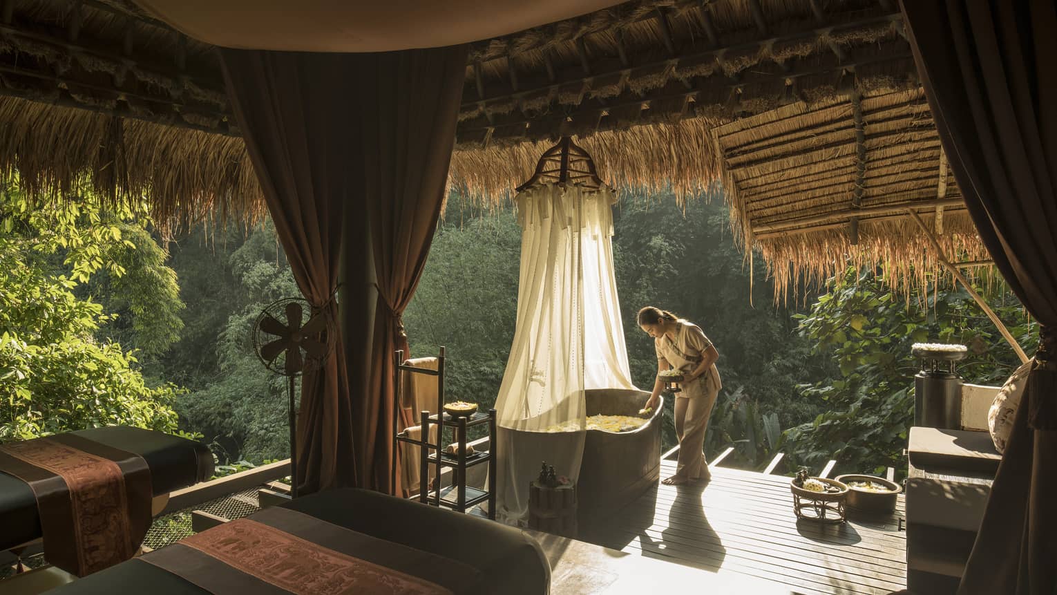 Woman prepares a bath on the jungle terrace
