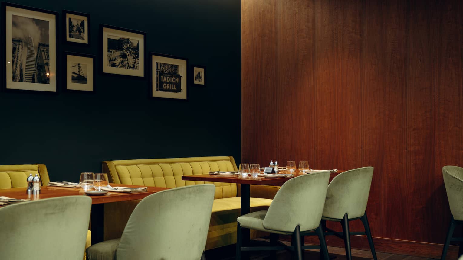 Dining room with yellow booths and picture frames on the wall.