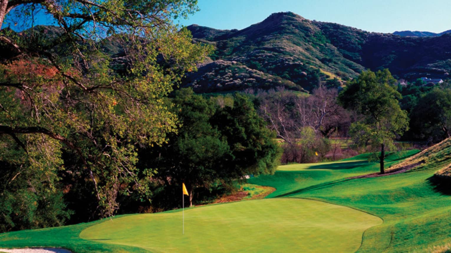A golf course with a beautiful mountain in the background.
