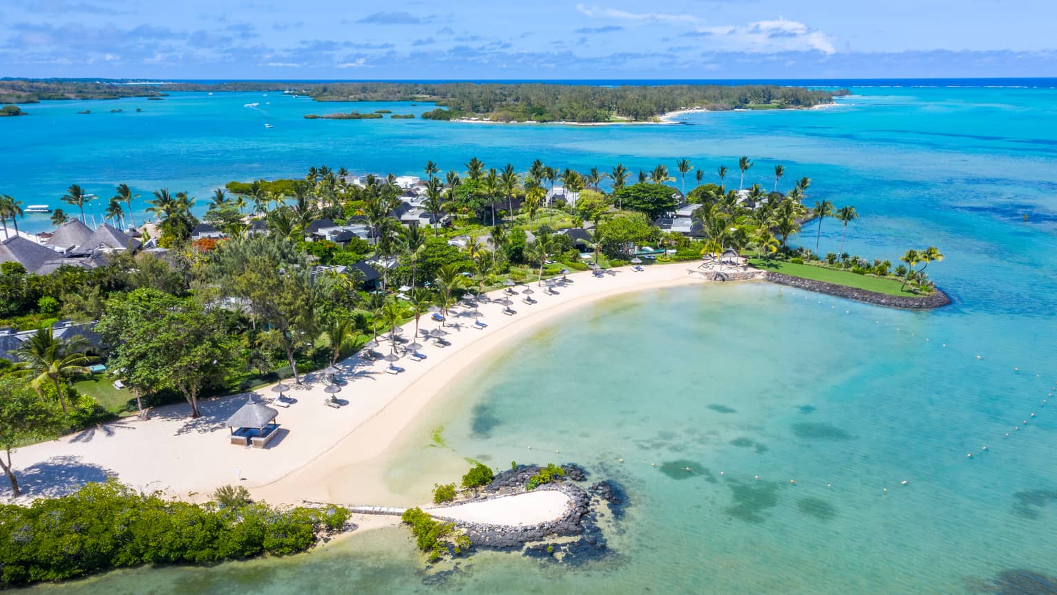 Aerial view of Four Seasons Resort Mauritius at Anahita and surroundings, including white-sand crescent beach and ocean