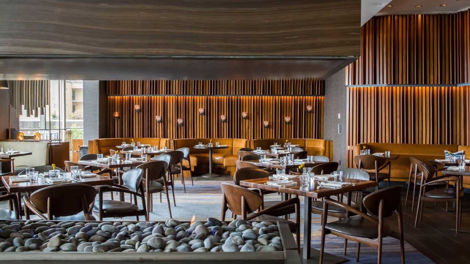 Goldfinch Tavern dining room beyond modern wood-and-stone gas fireplace