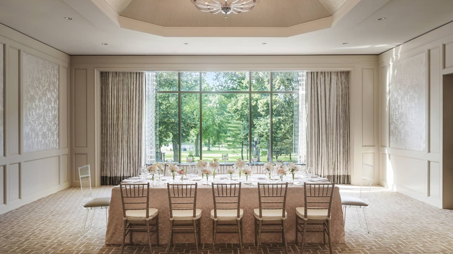 Private dining table with flowers under dome ceiling with crystal chandelier, by sunny window