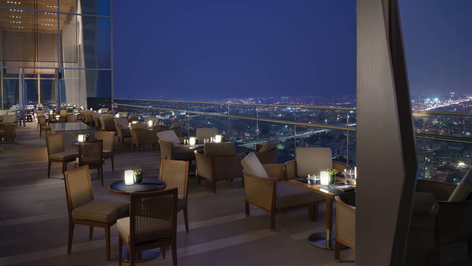 Several tables set up on the outdoor terrace overlooking Kuwait