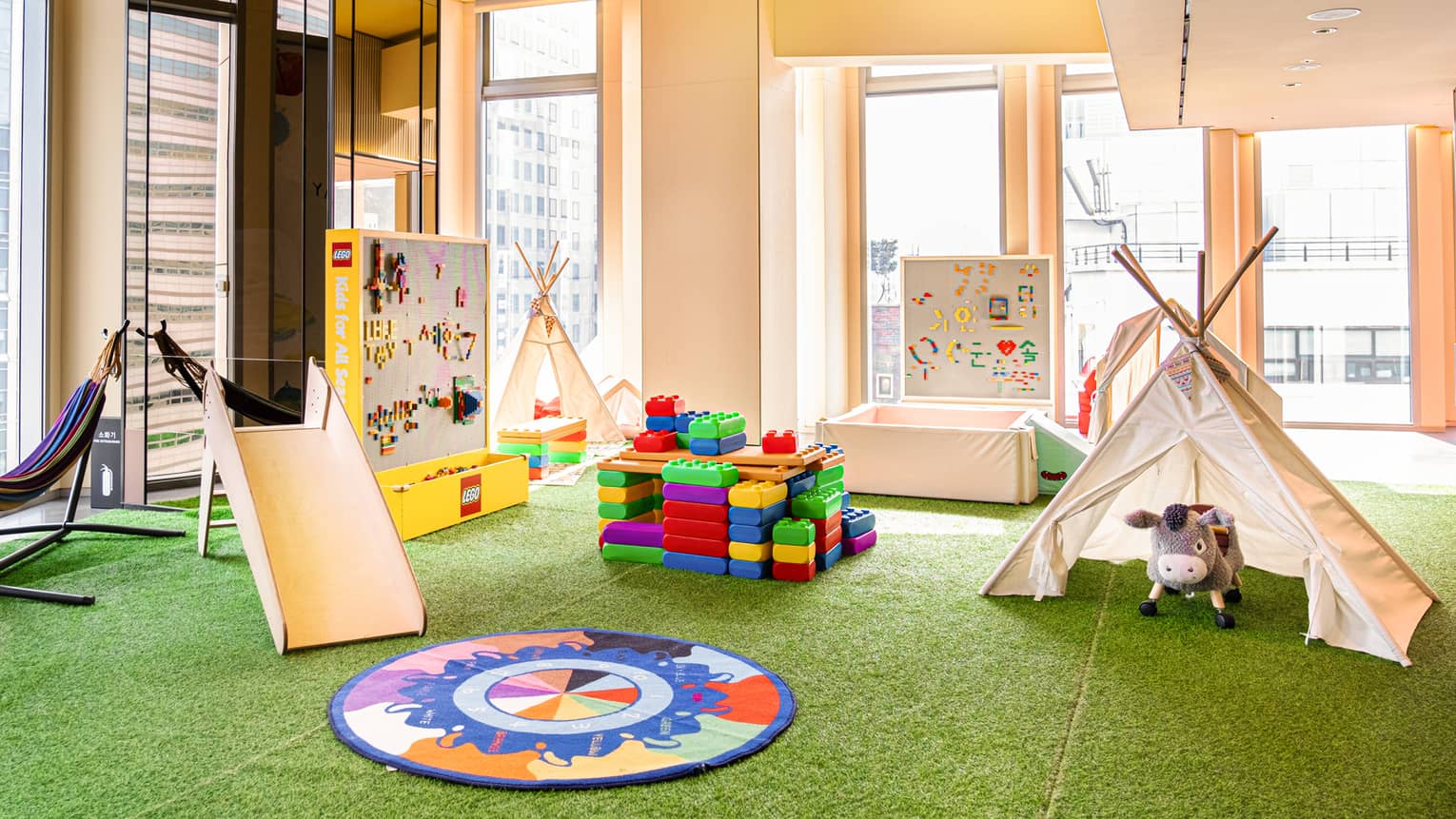 Light-filled Kids for All Seasons Lounge with colourful blocks, teepees and other activities