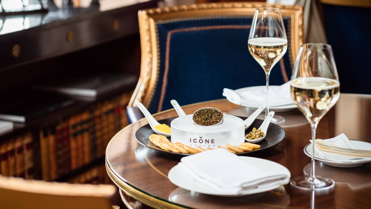 Caviar and crackers next to glasses of wine.