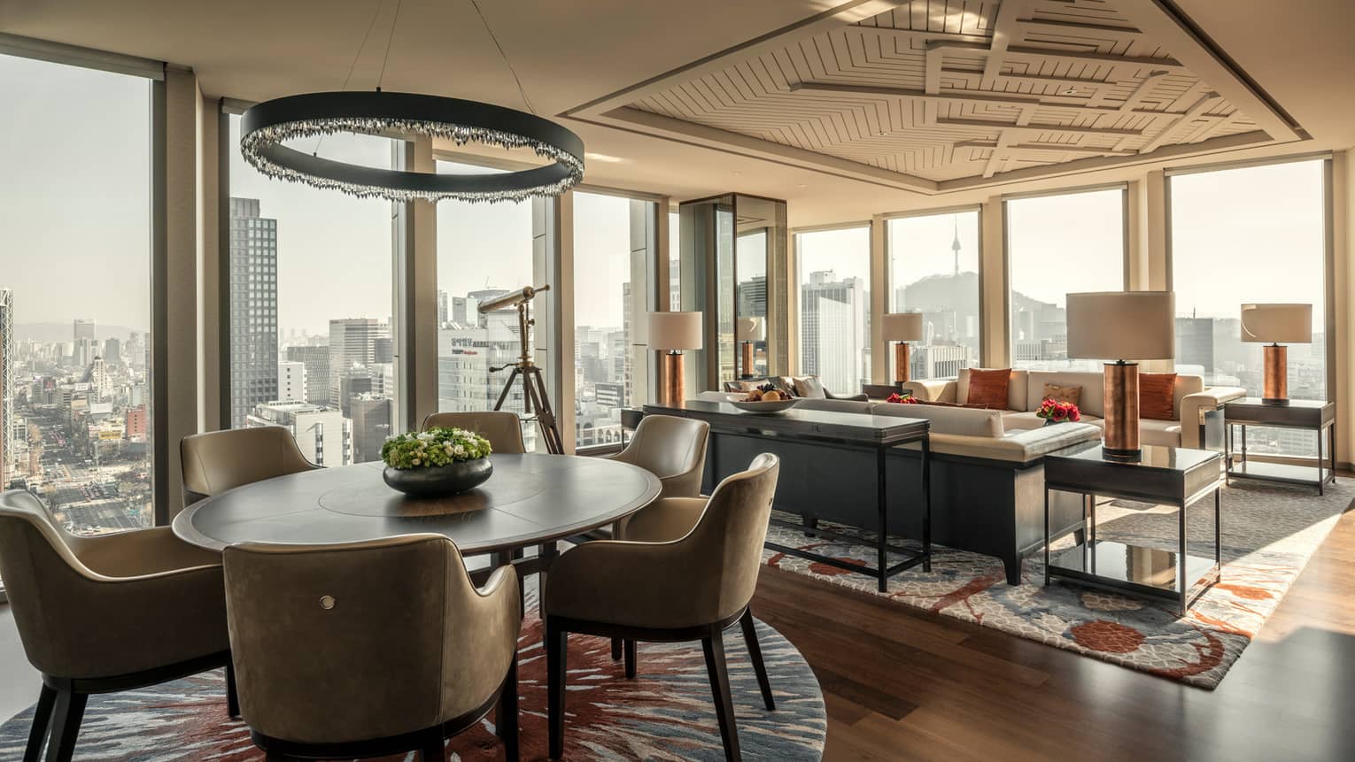 Sejong Two-Bedroom Suite round dining table under modern chandelier, seating area, corner windows