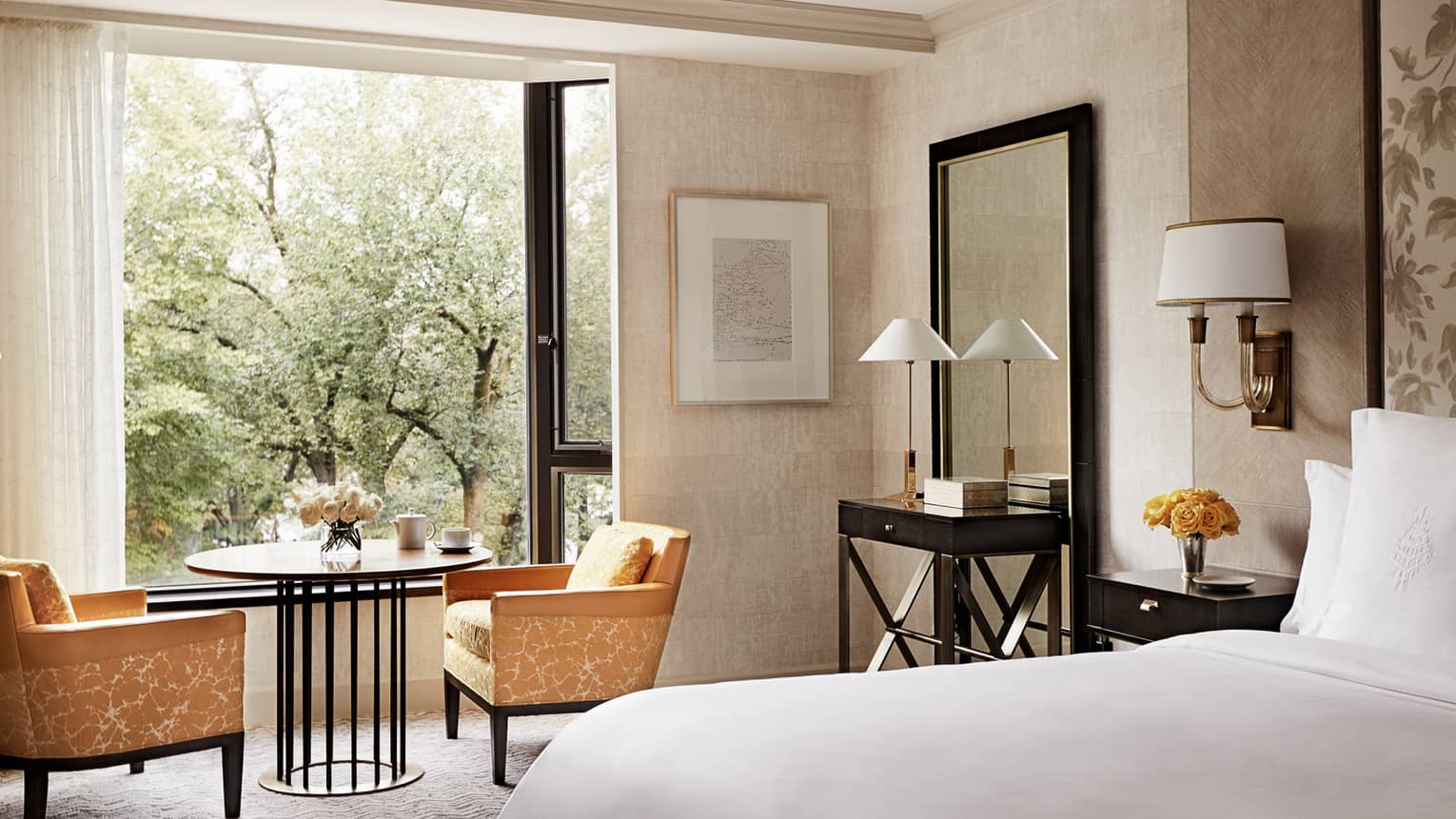 Deluxe Garden-View Room sunny window with treeview, yellow chairs with cafe-style table, coffee mug, partial view of bed