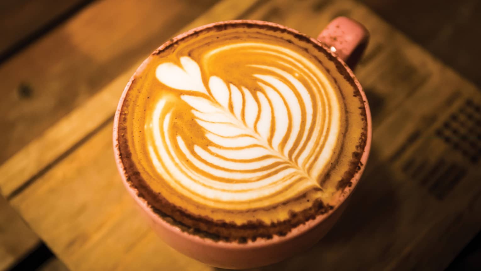 Close-up of latte coffee with flower design in foam