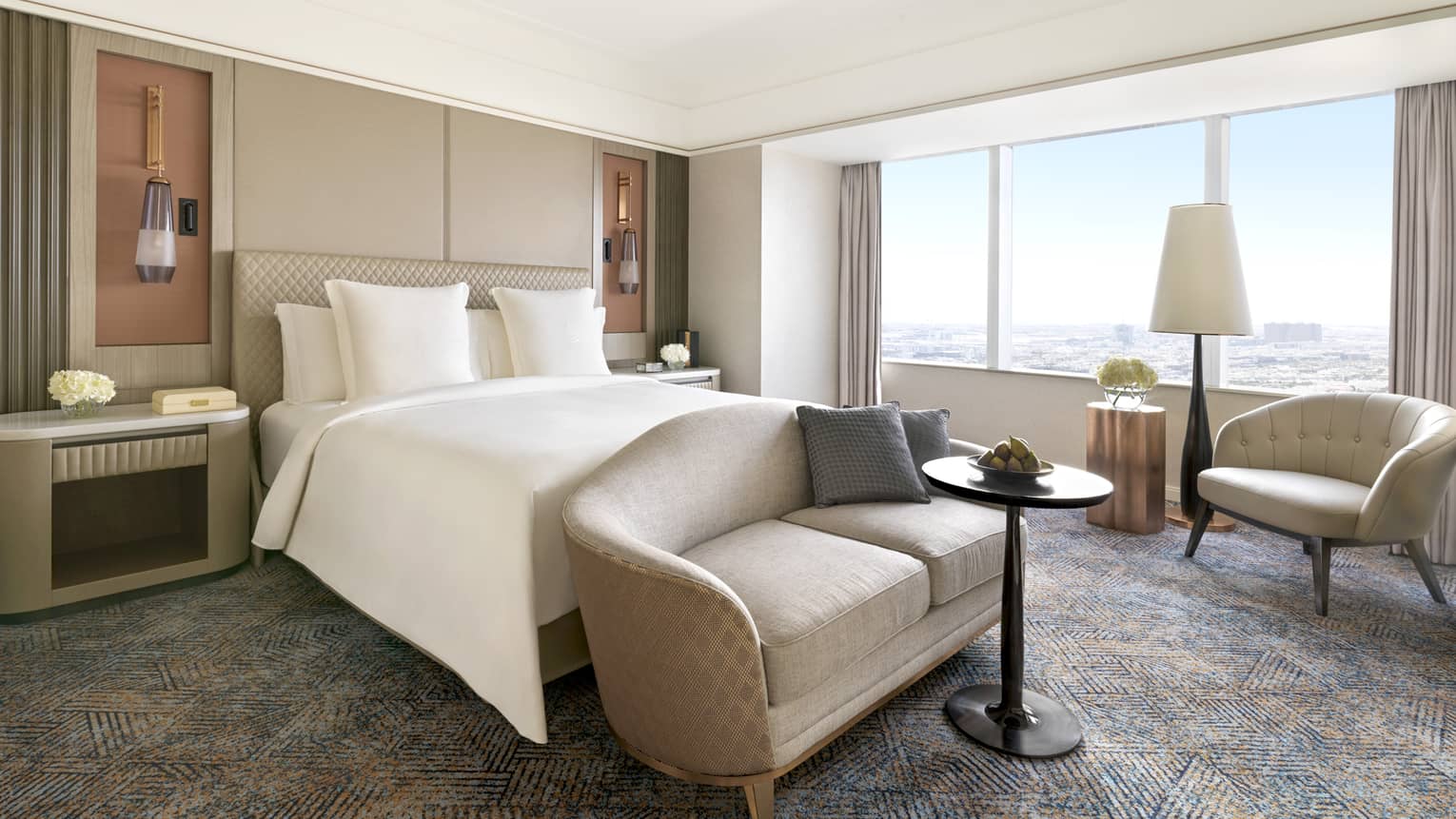 Bedroom with king bed, chaise and arm chair by the window