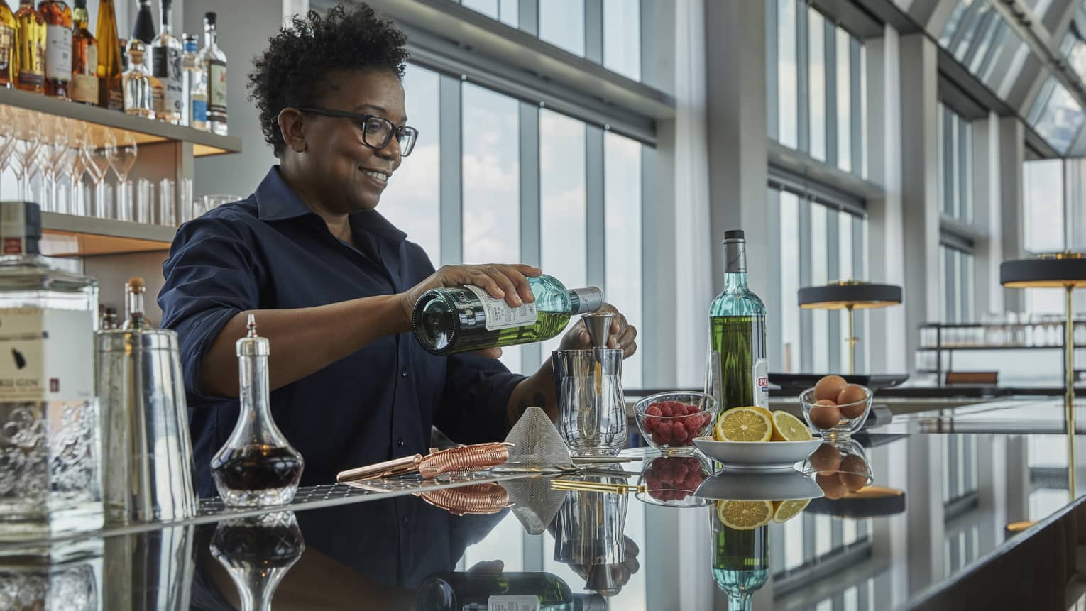 A four seasons bar tender pours a drink at the bar