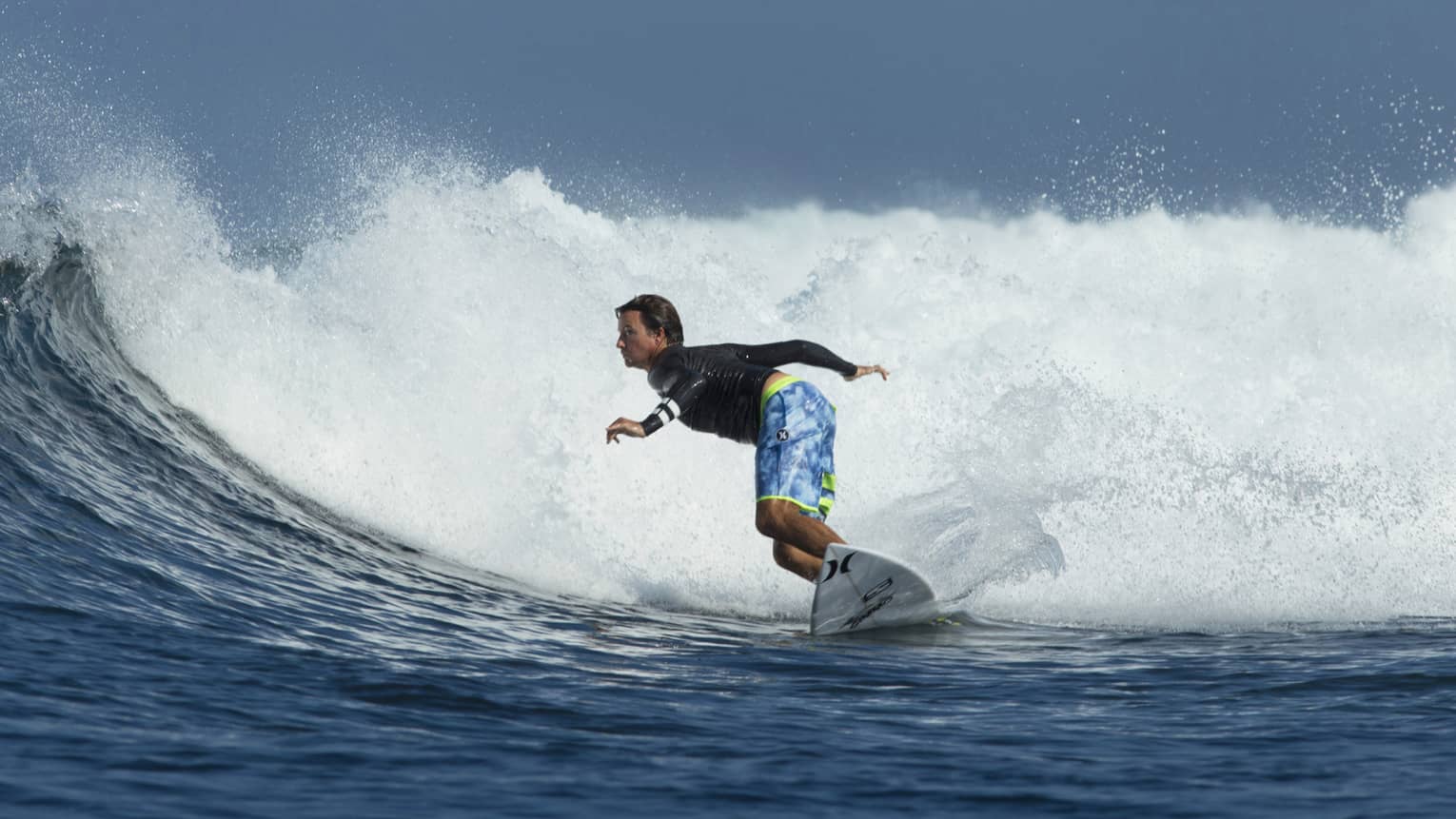A guest surfs on the water in Bali with TropicSurf