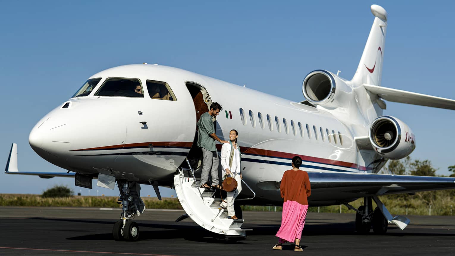 A man and woman walking off of a plane.