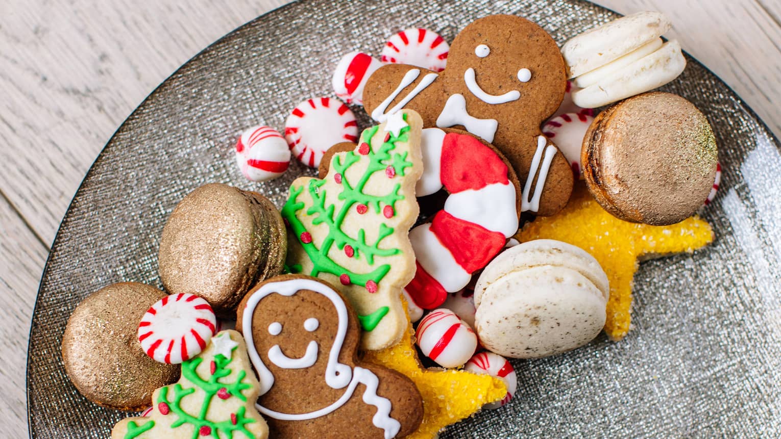A plate of holiday sugar cookies – christmas trees and ginger bread men and candy canes