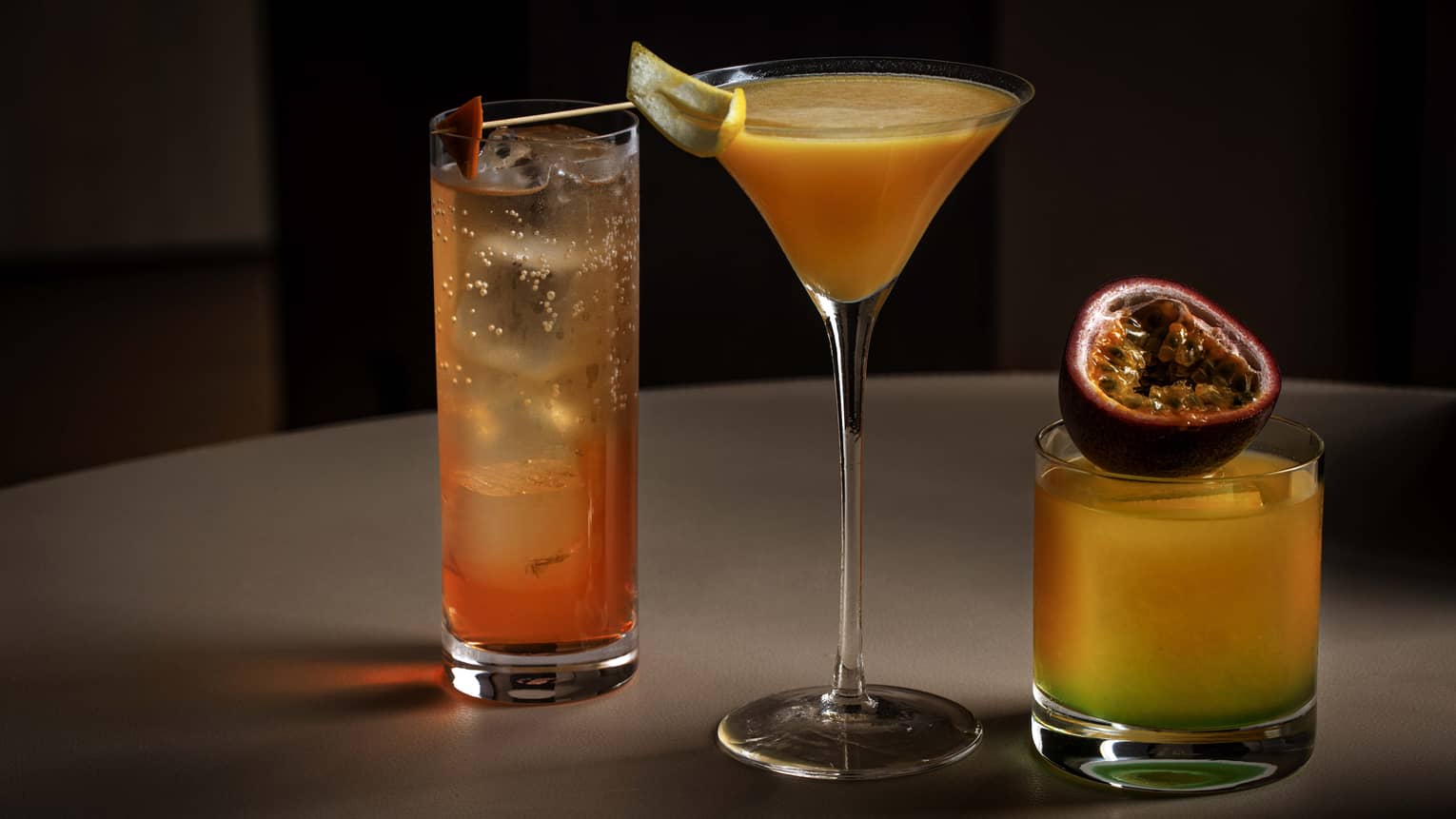 Trio of mango-flavoured cocktails on round tabletop