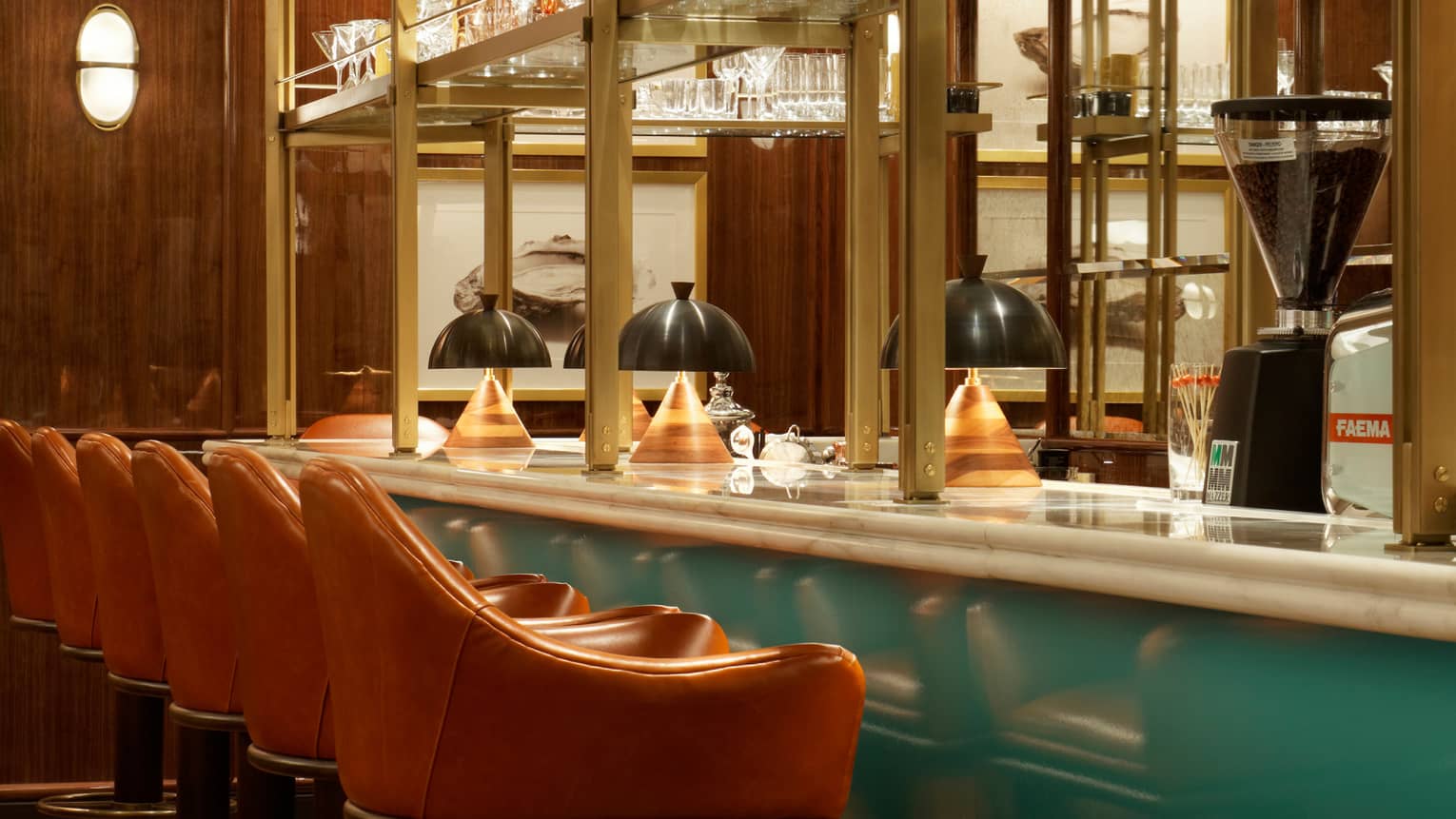 Orange leather stools line turquoise Cafe Boulud bar with modern wood lamps