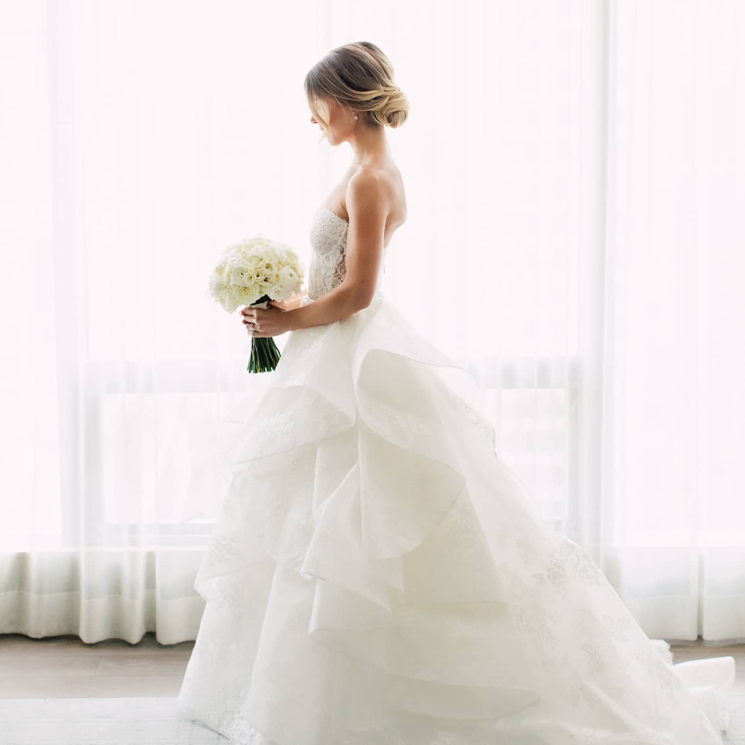 bride on wedding day with bouquet of flowers in luxury hotel