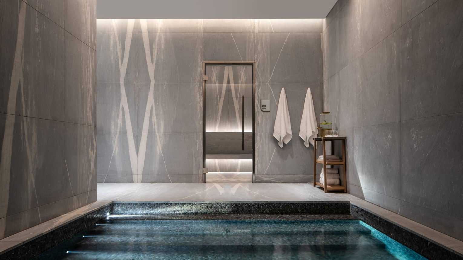 Slate-walled spa area with steps that lead into a pool