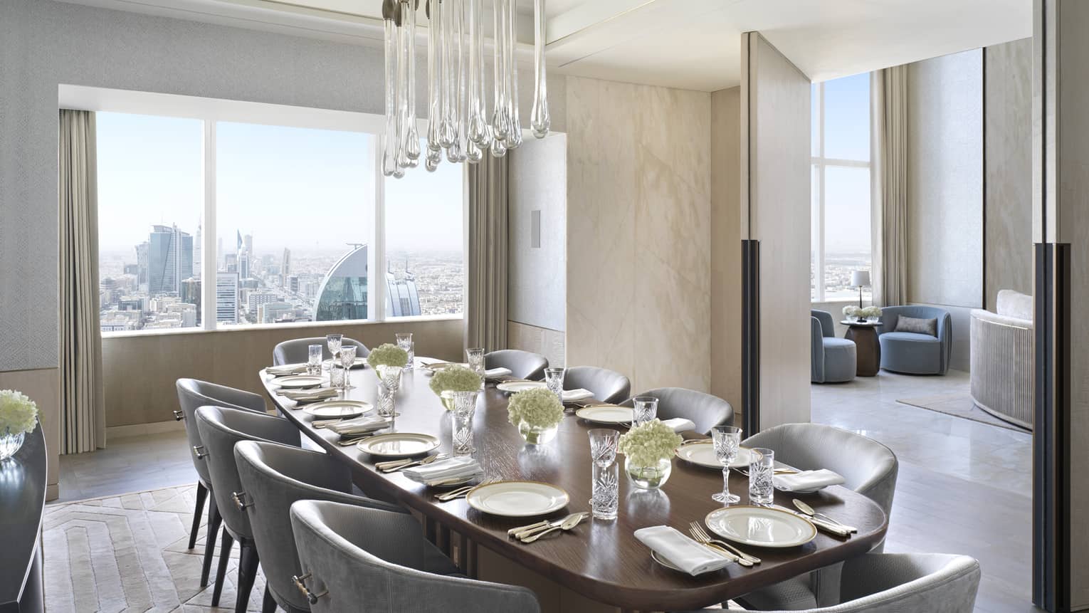 Dining room with table set for 10, modern crystal chandelier and window