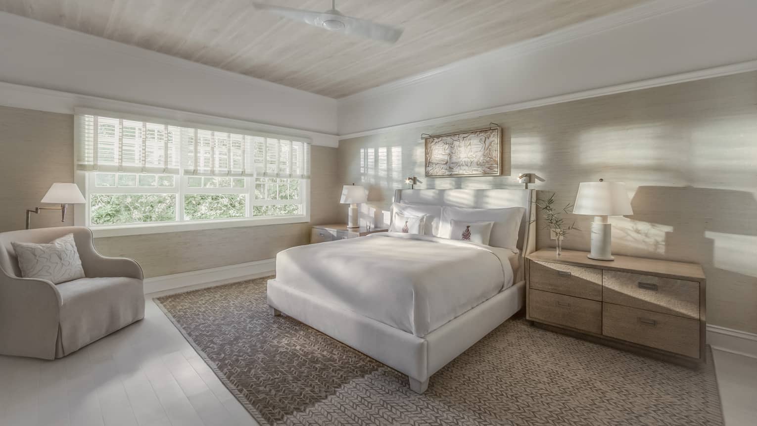 Sunlight and shadows shine through the window of a master suite bedroom