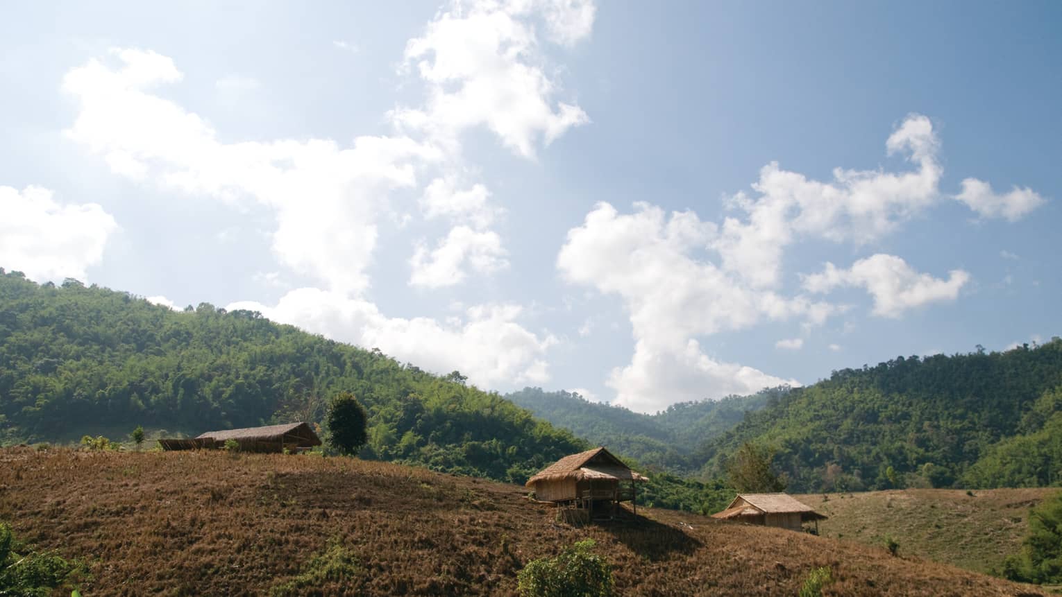 The rolling hills of Wang Lao Trail, blue sky and fluffy white clouds