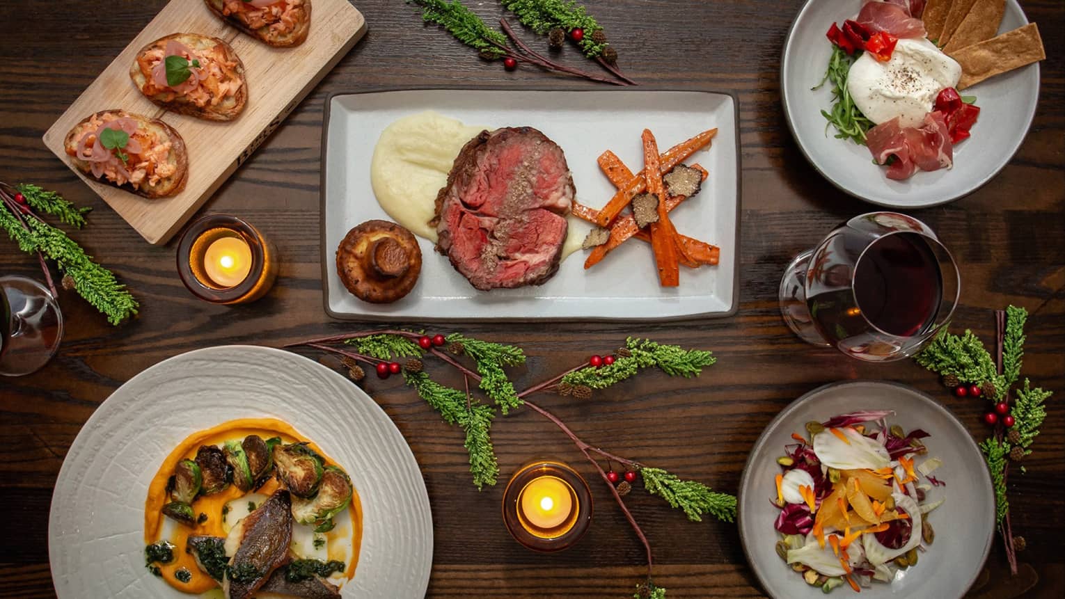 An assortment of holiday food on white and wood trays.