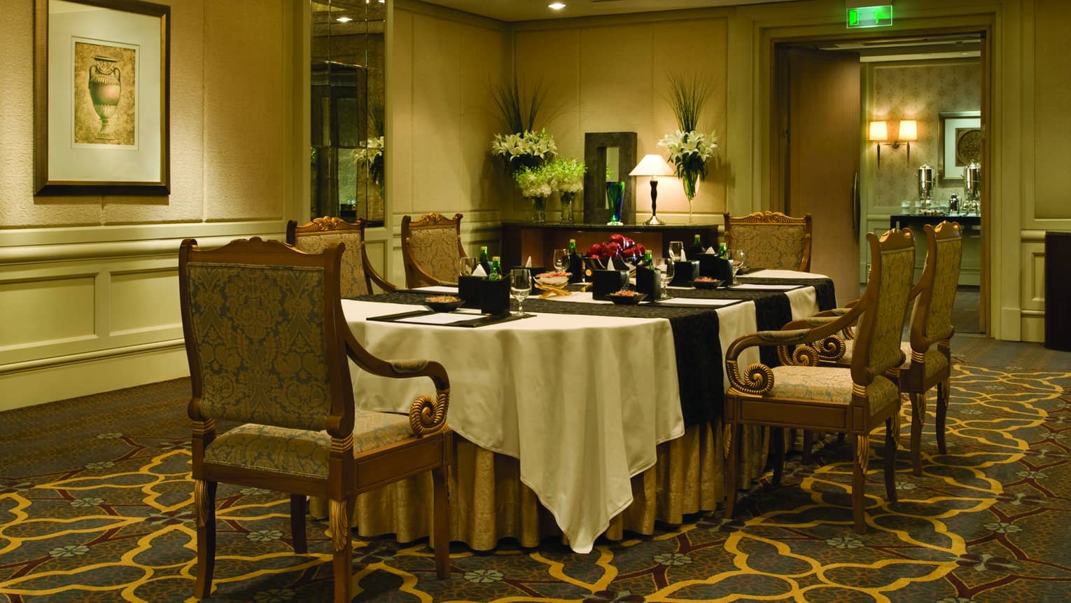 Small room with dining table, ornate dining chairs, carpet floor, chandelier