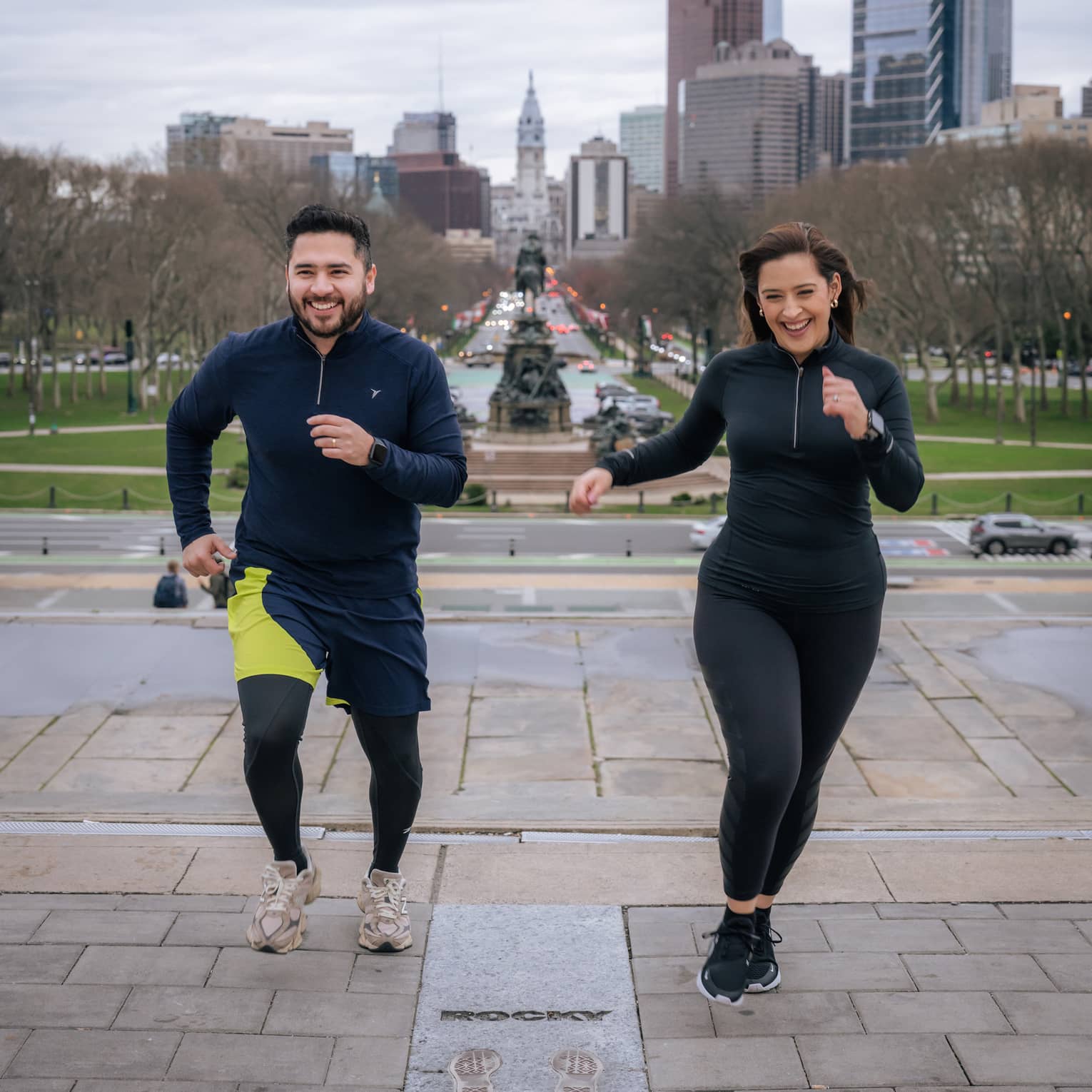 Two guests wearing exercise clothes and running outside.