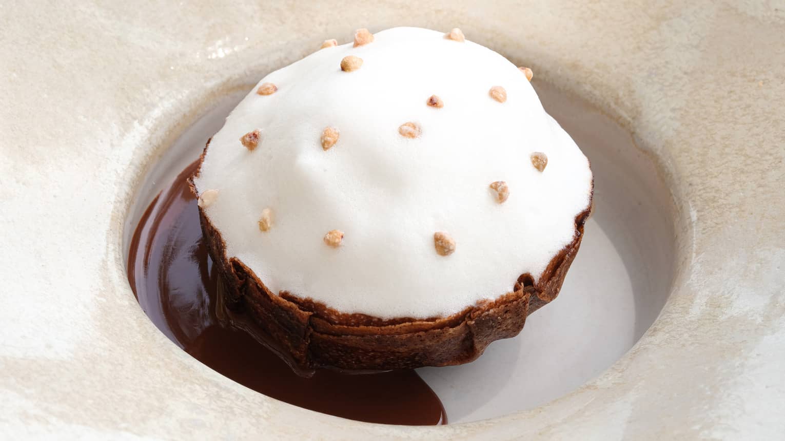 Crispy chocolate and hazelnut cake topped with milk foam
