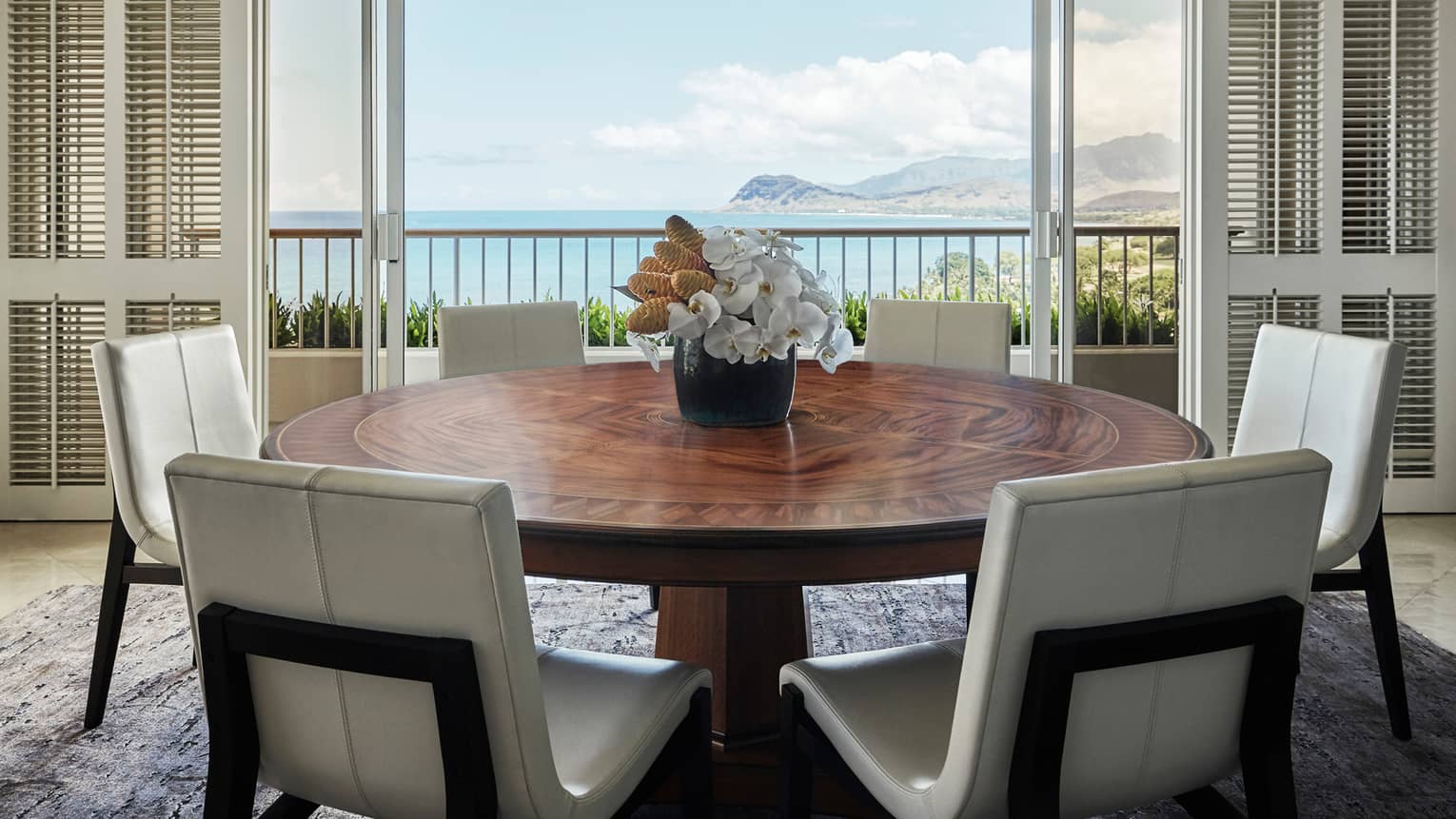 White chairs at large wood dining table under modern black light