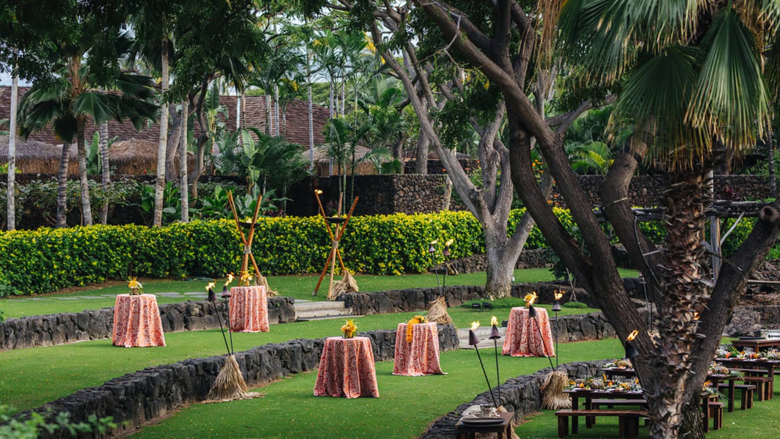 Small cocktail tables line event tiered event lawn with stone ledges 