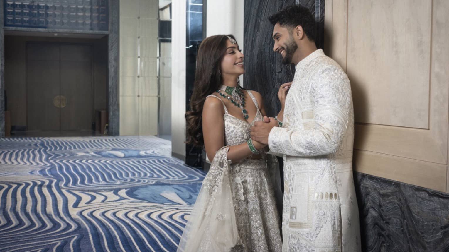 Man and woman embrace in a large ballroom / event venue