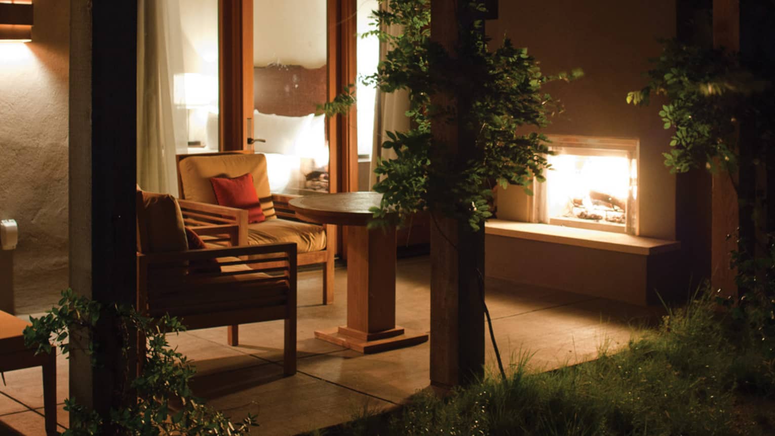 Casita patio chairs, wood beams, outdoor fireplace at night