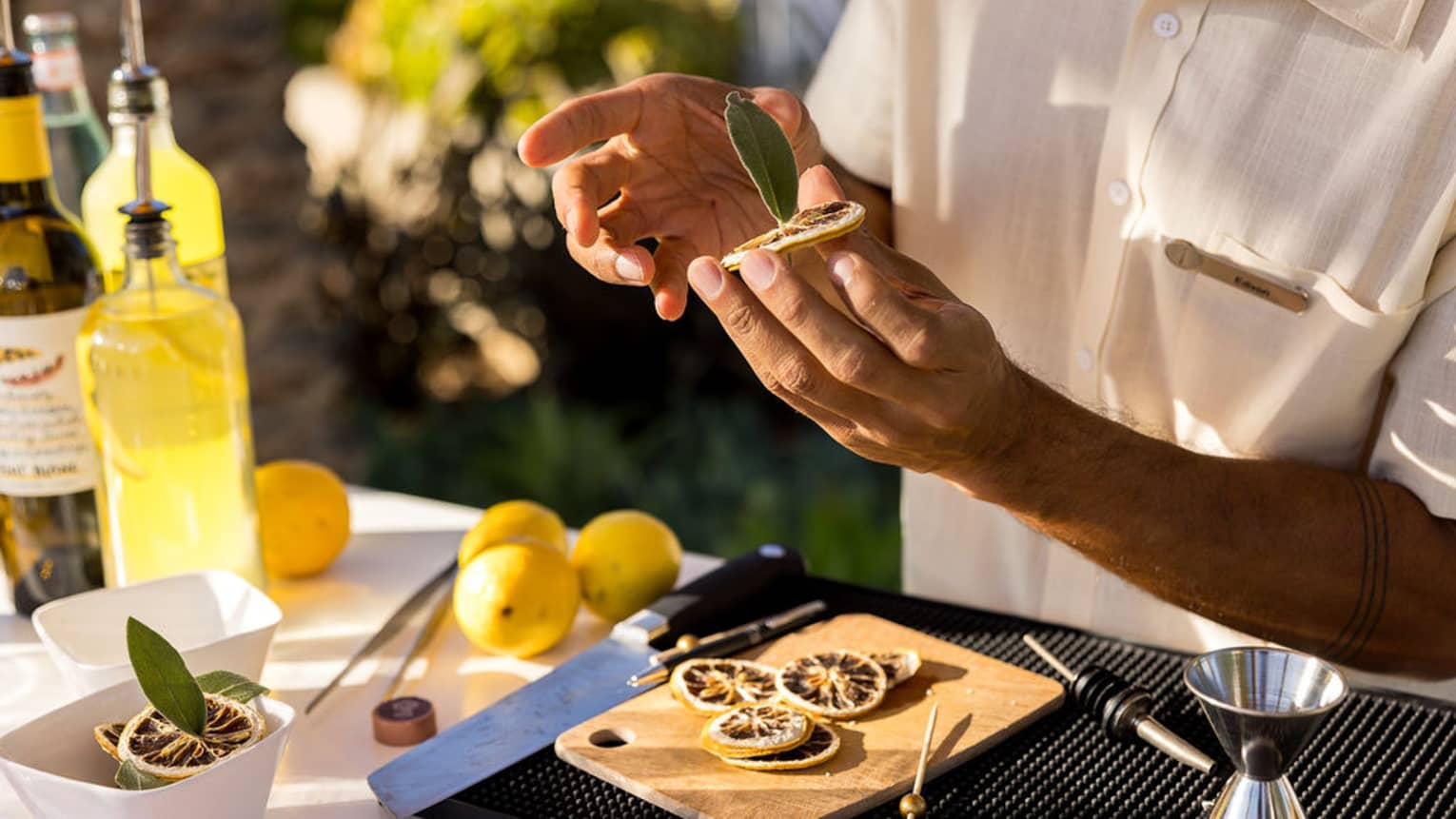 Bartender places a leaf in the centre of a dried citrus