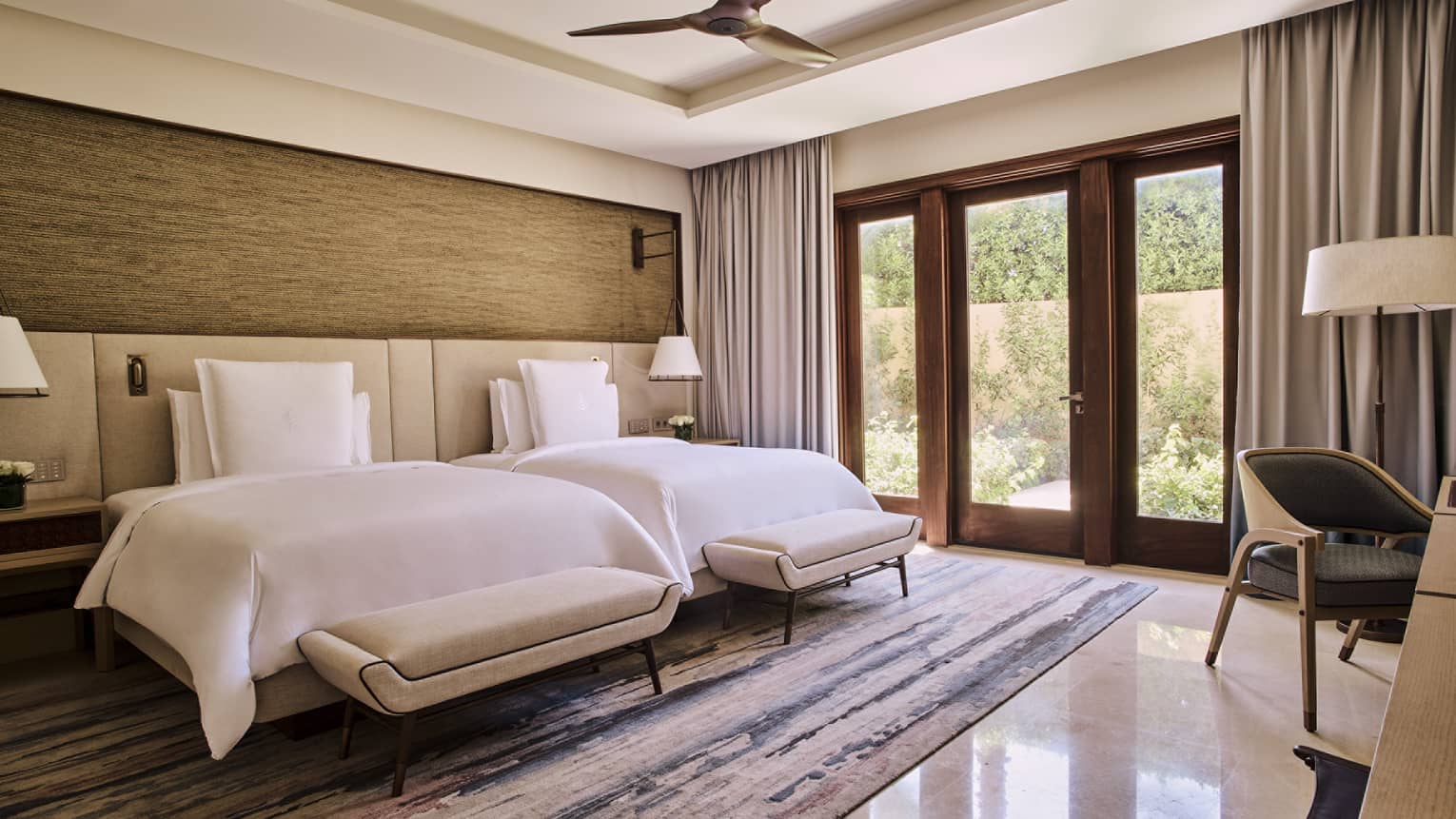 Luxury bedroom with two beds and doors to terrace